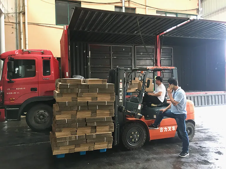 Beladen von maßgefertigten Kartons in einen Container